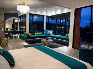a room with a bed and a living room with windows at On Eagle Wings Mountain Retreat & Spa in Neranwood