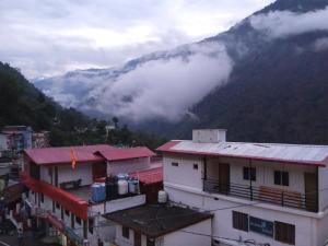 a view of a building with a mountain in the background at Trinetra Himalayan Stay in Phata