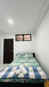 a bedroom with a bed with pillows on it at Belga Boarding House in Guimaras