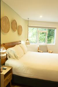 a bedroom with a large white bed and two windows at 574 Hotel in Medellín