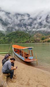 a group of people on the beach next to a boat at Nongkhiaw Camping 360 c top mountain view in Nongkhiaw