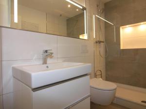 a white bathroom with a sink and a toilet at Ferienwohnung auf Fehmarn in Orther Reede in Orth +27 photos