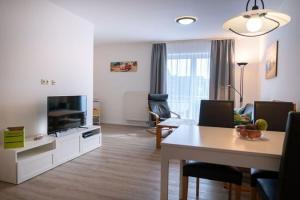 a living room with a television and a dining table at Ferienwohnung auf Fehmarn in Orther Reede in Orth