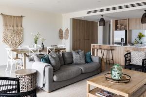 a living room with a gray couch and a kitchen at The Jetty, Port Willunga in Port Willunga