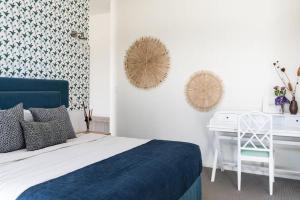 a bedroom with a blue bed and a desk at The Jetty, Port Willunga in Port Willunga