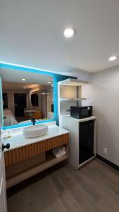 a bathroom with a sink and a kitchen at Harbor Bay Inn in Costa Mesa