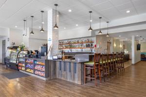 a restaurant with a bar with wooden stools at Best Western Plus Ocean View Resort in Seaside