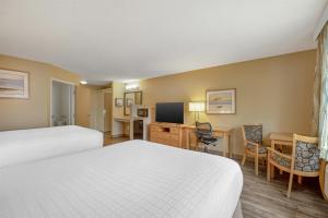 a hotel room with two beds and a desk at Best Western Plus Ocean View Resort in Seaside