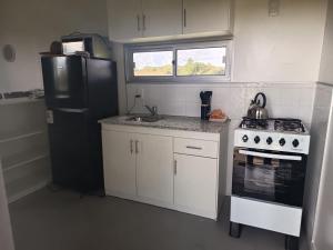a kitchen with a black refrigerator and a stove at Refugio Don Rogelio in Minas