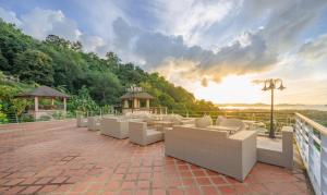 a patio with white chairs and a view of the ocean at The View Rawada Phuket in Rawai Beach