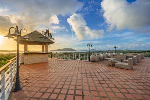 a patio with couches and chairs on a roof at The View Rawada Phuket in Rawai Beach