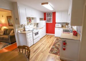 a kitchen with white cabinets and a red wall at Over the Rainbow Suites in Eureka Springs