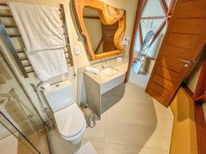 a bathroom with a toilet and a sink and a mirror at Ville do Lago in Gravatá +24 photos