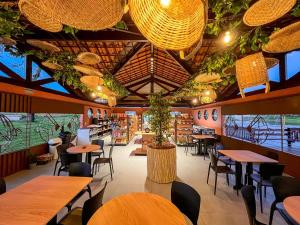 a restaurant with wooden tables and chairs and lights at Ville do Lago in Gravatá