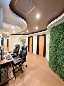 a office with two chairs and a green wall at Gumi stayraum in Gumi