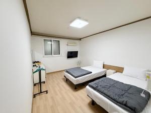 a room with two beds and a flat screen tv at Gumi stayraum in Gumi +21 photos