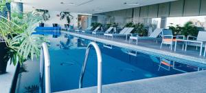 a swimming pool with chairs and tables in a building at On Paseo de la Reforma, great location, luxurious, pool, gym in Mexico City