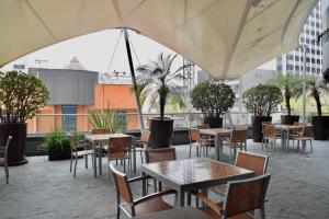 an outdoor patio with tables and chairs and trees at On Paseo de la Reforma, great location, luxurious, pool, gym in Mexico City