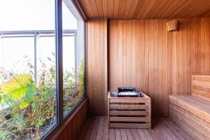 a sauna with a bench and a large window at GRU Residence by Housi in Guarulhos +97 photos