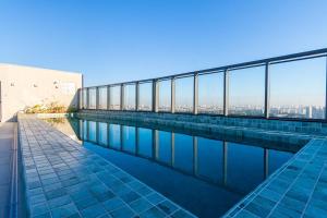 a swimming pool with a view of the city at GRU Residence by Housi in Guarulhos