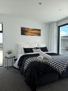 a bedroom with a black and white bed and a window at Darfield Retreat in Darfield