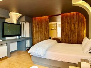 a bedroom with a bed and a flat screen tv at 로미오앤줄리엣 in Daegu