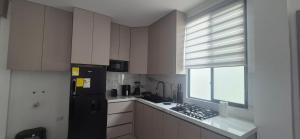 a kitchen with a black refrigerator and a window at Renata's Depar in Punta Blanca