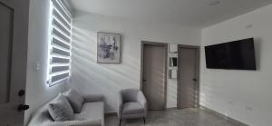 a living room with a couch and a tv on a wall at Renata's Depar in Punta Blanca