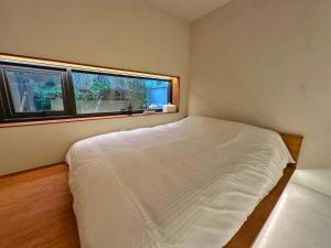 a bedroom with a white bed and two windows at 광안해옥 in Kwangan-dong