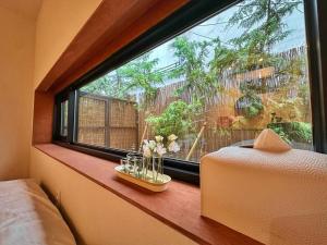 a bedroom with a window with flowers on a window sill at 광안해옥 in Kwangan-dong +5 photos