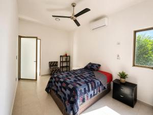 a bedroom with a bed and a ceiling fan at Casa Mayi Private house with pool in Chablekal in Chablekal