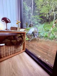 a room with a large window with a cat in a basket at Secret Garden by Tiny Away in Uki
