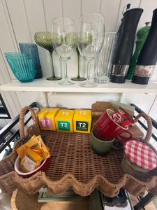 a shelf with wine glasses and other items on it at Secret Garden by Tiny Away in Uki
