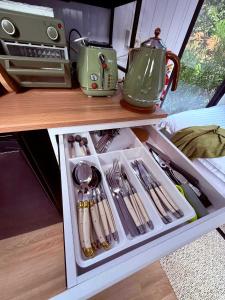 a drawer in a kitchen with utensils at Secret Garden by Tiny Away in Uki +11 photos