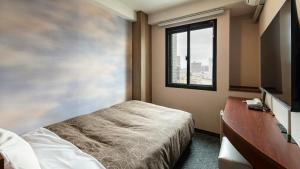 a bedroom with a bed and a window at Hotel Resh Tottori Ekimae in Tottori +18 photos