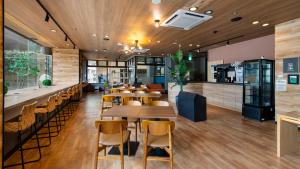 a restaurant with wooden floors and tables and chairs at Hotel Resh Tottori Ekimae in Tottori