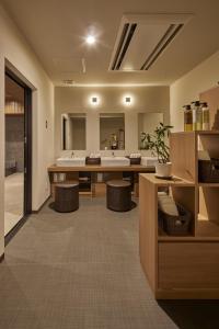 a bathroom with a sink and a large mirror at Hotel Resh Tottori Ekimae in Tottori