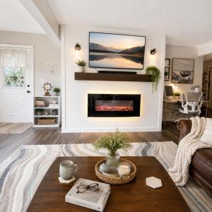 a living room with a fireplace with a tv above it at Tranquil Retreat - Close to everything you need in Osage Beach