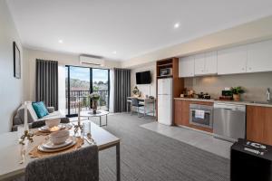 an open kitchen and living room with a table at Quest Mont Albert in Box Hill