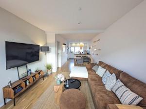 a living room with a large couch and a flat screen tv at Heilige-Hafen-Lodge in Heiligenhafen