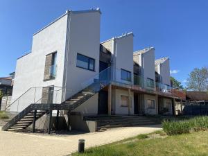 a white building with a staircase in front of it at Heilige-Hafen-Lodge in Heiligenhafen