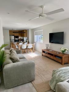 a living room with a couch and a flat screen tv at Private 3 Bedroom - 200m to the Beach in Mooloolaba