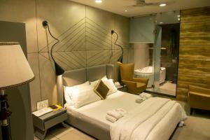 a bedroom with a large bed and a bathroom at Hotel Welcome Palace in Surat +47 photos