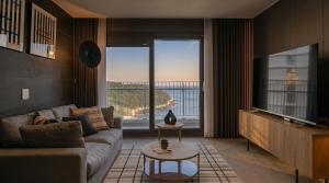 a living room with a couch and a large window at Le Collective Busan Gijang in Busan