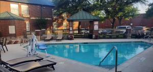 a swimming pool with chairs and a gazebo at Clarion Pointe Addison - Dallas North in Addison