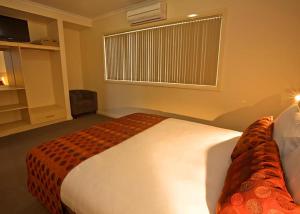 a hotel room with a bed and a window at Hibernian Hotel in Beechworth