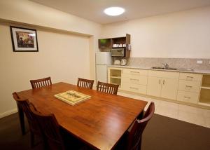 a kitchen with a wooden table with chairs and a kitchen at Hibernian Hotel in Beechworth