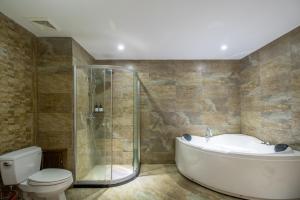 a bathroom with a tub and a toilet and a shower at Zhangjiajie Cloudscape Courtyard Hotel-Vegan Available, Chinese Retro Style,Tea Culture Experience, Free Breakfast ,Travel Guide& Book Tickets,Friendly Host,Orient esthetics in Hanqiyu +79 photos