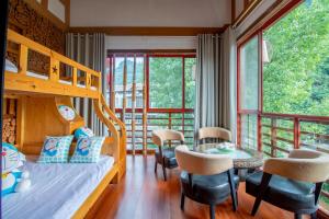 a bedroom with a bunk bed and a table and chairs at Zhangjiajie Cloudscape Courtyard Hotel-Vegan Available, Chinese Retro Style,Tea Culture Experience, Free Breakfast ,Travel Guide& Book Tickets,Friendly Host,Orient esthetics in Hanqiyu
