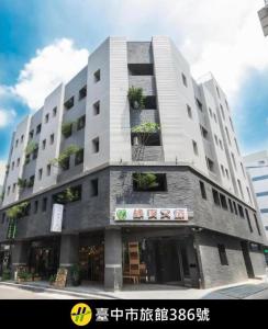 a large white building with potted plants on it at Greenight Hotel in Taichung